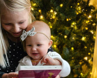 Happy toddler and older sister enjoying Owl Post Books kids subscription box with holiday gift books, perfect Christmas present