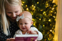 Happy toddler and older sister enjoying Owl Post Books kids subscription box with holiday gift books, perfect Christmas present