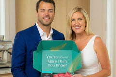Founder holding a Senior Joy Box subscription box filled with colorful gifts and snacks for aging parents