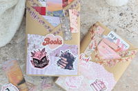 surprise book box with new book, annotation supplies, relaxation and self care items packaged neatly in a box