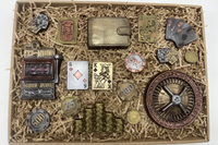 Box with casino-themed chocolates including a roulette wheel, poker chips, wallet, and detailed playing card shaped treats