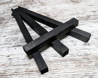 Small black wooden easel collapsed and lying flat on a table. Included in the Deconstructed Hearts Box to display the torn paper art piece.