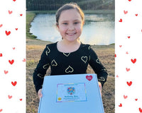 Happy child with February Activity Box. February Valentine's box with 20 OT activities, crafts, sensory materials, and fine motor tools for 