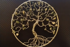A wire sculpture tree set in a ring with tree agate leaves on the branches. Made with our Wire Sculpture Crate. Black background.