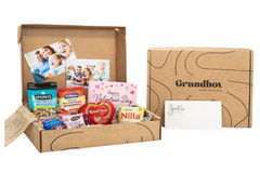 Grandbox Valentine’s Day gift box with snacks, chocolates, family photos and a personalized card, designed as a care package for loved ones.