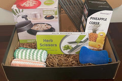 A subscription box full of different kitchen gadgets that are used for cooking, meal prep, or clean up.