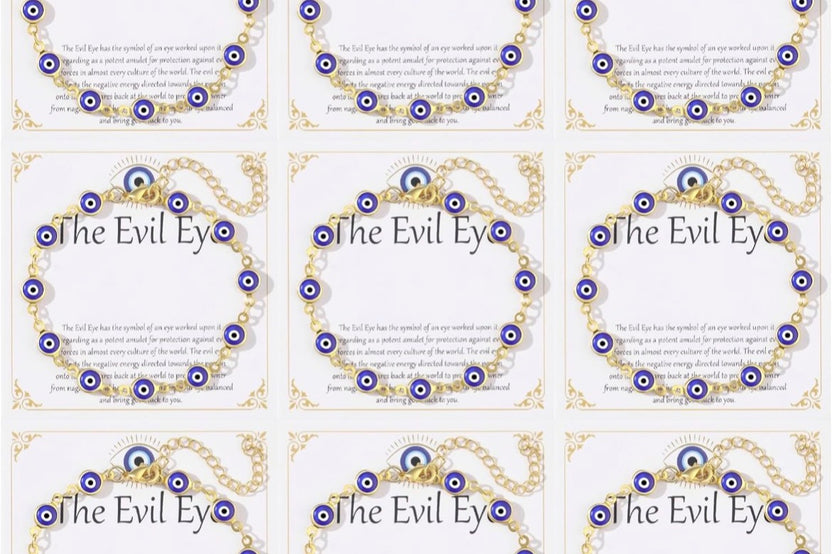Nine 14K gold plated evil eye bracelets displayed on white 'The Evil Eye' gift cards, each with blue evil eye charms on a gold-tone chain.