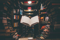 levitating book that is surrounded by many books in the front but also in the background. The colors are moody