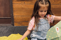 Happy child excitedly showing off a Wiggle Worms Kit, filled with creative crafting supplies........