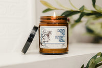 a candle with the Tenniel White Rabbit illustration on it. The candle is called done the rabbit hole. 