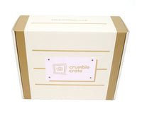 Bright lemon cupcakes topped with pink strawberry buttercream swirls and white sugar pearls in a baking kit setup