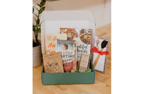 Box of Books subscription box featuring two novels, a cookbook, chocolate, and kitchen items for book lovers