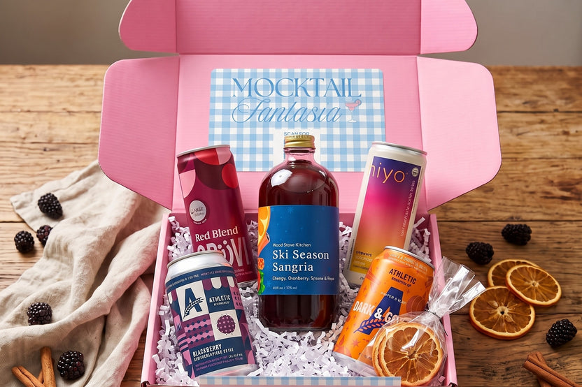 Fall mocktail box with Athletic Blackberry NA sour, Ski Season Sangria mixer, and Grüvi Red Blend, with blackberries and orange.
