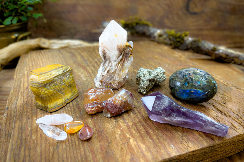 Enchanted Crystal subscription box on wooden table, with multiple crystals arranged and bonus mini crystals