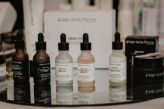 Many skin care products from a popular brand next to each other on a mirror. All of the are mens self care products.