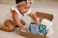 Baby looking though subscription cupcake cloth diaper subscription box. 