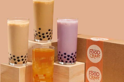 Four homemade bubble tea drinks, including classic milk tea, taro milk tea, brown sugar tea, and fruit tea served with chewy tapioca pearls 