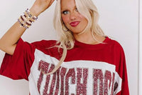 Woman wearing a red TOUCH DOWN shirt and the Game Day 8-piece stackable friendship bracelet set, with beaded bracelets and football charms s
