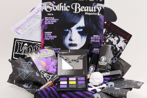 Gothic Beauty subscription box featuring magazine, goth-themed accessories, and spooky goodies arranged in a decorative package