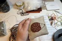 Customer holding a craft kit featuring woodland animals to make lavender filled pillows to place in a wardrobe or drawer.