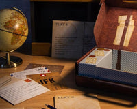 High quality photo of a box with mystery escape game called the JFK and with a globe sitting next to it as decoration.
