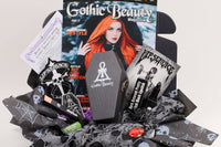 Gothic Beauty subscription box featuring magazine, goth-themed accessories, and spooky goodies arranged in a decorative package