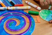 A young girl working on the wooden solar system mobile craft