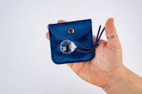 A bright prism held in a hand, one of the sensory treasures from Tía’s Box of Treasures that encourages play and discovery.