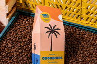 Two bags of coffee, a Goodbirds box and a cup of coffee, part of Goodbirds monthly coffee subscription of 2 12oz bags of coffee