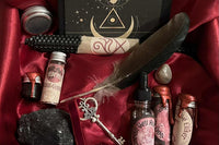 The Blood Moon Box. Moonstone, Black Tourmaline, Ink & Quill, Crimson Veil Anointing Oil & Incense, Black Beeswax, Key, Elixer & Journal