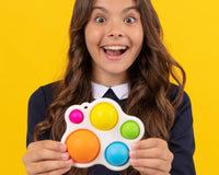 Teen Girl laughing and holding a large bubble pop fidget toy from Box of Sensory Toys in front of her in her hands.