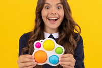 Teen Girl laughing and holding a large bubble pop fidget toy from Box of Sensory Toys in front of her in her hands.