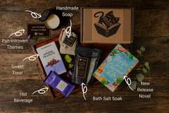 Introverts Retreat flatlay on wood with each item and the box. Items are labeled with white lettering.