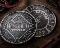 Very Hugh quality and close up photo of 2 tokes or coins with the word arcade and spaced out on them.