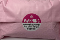 Pink bubble mailer packaging with a warning label sticker that reads opening this package will cause extreme happiness, shown as part of pro