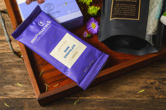 Introverts Retreat box items including a purple bag of dark chocolate cocoa on a tray with chocolate covered nuts.