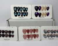 Display cards showing multiple sets of press-on nails in different colors and designs, neatly arranged to showcase variety in styles, shapes