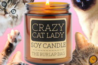 Crazy Cat Lady 9oz soy candle by The Burlap Bag, grapefruit scented amber jar surrounded by cat faces on a pink background