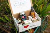 The Nevada Box shows what customers received by showcasing an open box with a drink, dice, coaster and various food items.