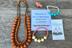 Box of Blessings featuring Uganda and Kenya: paper bead necklace, two paper bead bracelets, soapstone animal, paper bead earrings