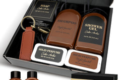 box full of mens shampoos and shower gels and other mens spa products in a box made of black carboard.
