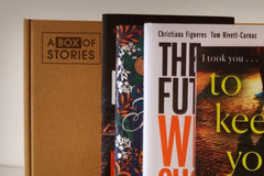 Brown box filled with fiction books, showcasing a variety of gripping titles and intriguing covers, perfect for mystery lovers.