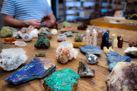 Enchanted Crystal holding a crystal selection for the crystal subscription box over a wooden table with more crystals