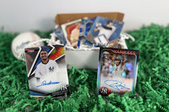 New York Yankees baseball cards arranged in display stands on green crinkle-cut paper with a ball and box of inserts