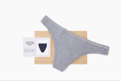 Pair of underwear (gray thong) featured in the monthly subscription along with a notecard and shipping mailer