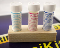 A blue box containing a forensikit is displayed in the back while a 3 chemicals for luminol science STEM experiments are in the foreground