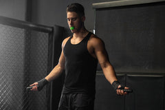 This image shows a fit male model jumping rope while using a Jawzrsize facial fitness device, a Q3 2024 Gainz Box product.