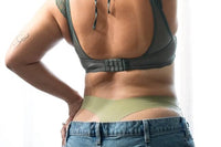 Backside of customer wearing a green thong underneath a pair of jeans that they received from the monthly subscription