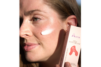 Woman applying Aster Lupine Seed and Rose Day Cream to face and under-eye area