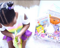 Young child reading beside an Owl Post Books kids subscription box filled with Baby Animals and crafts, a perfect holiday gift for toddlers.